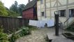 Achter een woning hangt de was te drogen.