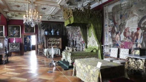 Een koninklijk bed in een slaapkamer.