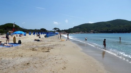 Het strand van Lacona met rechts op de heuvel een camping.