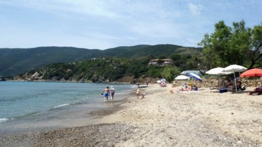 Het strand van Lacona naar de andere kant van de baai met ook op de heuvel een camping.